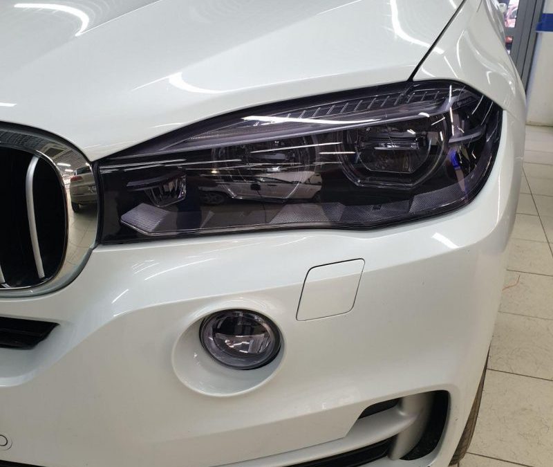 Бронирование фар автомобиля BMW X5 полиуретановой пленкой Stek с эффектом затемнения